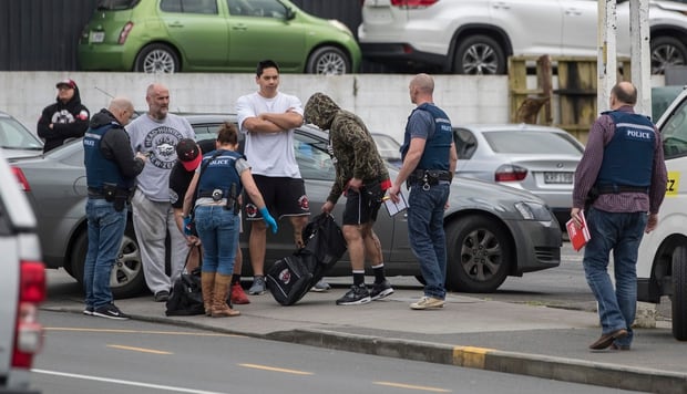 Police talk to club members after cordoning off Marua Road in Ellerslie while raiding the Headhunters Motorcycle Club clubrooms. Photo / NZ Herald