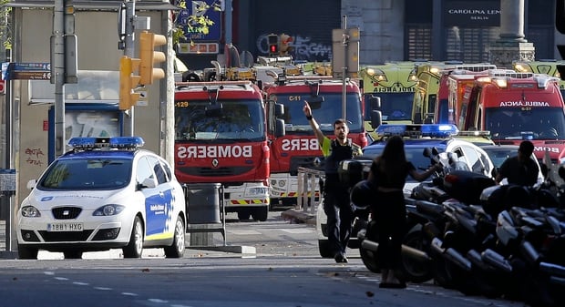 A police officer gestures as he blocks a street in Barcelona after the area around Las Ramblas was closed off following the terrorist incident. Photo / AP