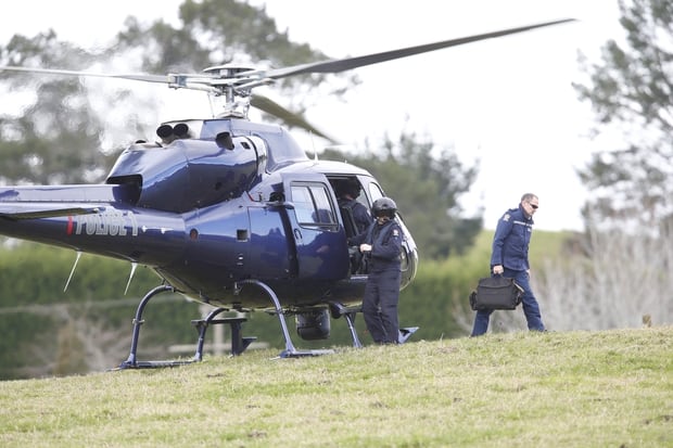 Policeman gets out of helicopter and walks towards authorities at the cordon in Whangarei. Photo / Northern Advocate