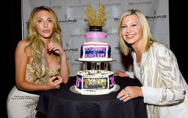 Singer Chloe Lattanzi (L) and her mother, singer/actress Olivia Newton-John, pose with a celebratory cake. Photo / Getty 