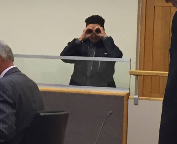 When Madams first entered the dock he hid his face from photographers before making eye goggles at them. Photo / Melissa Nightingale