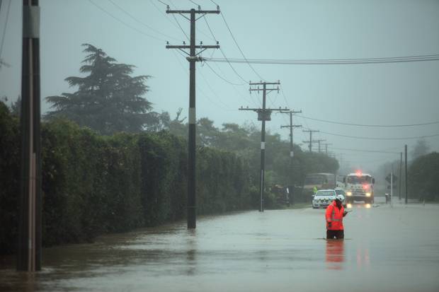 Rural fire chief Colin Eggers makes his way through floodwater in Riwaka. Photo / Tim Cuff