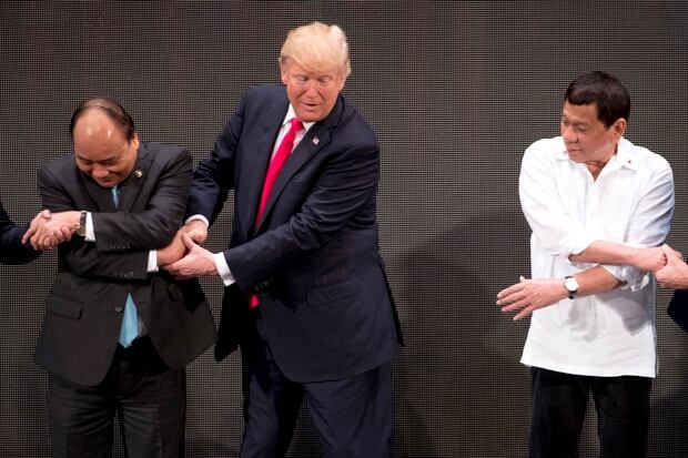 Trumpstruggles to come to grips with the handshake with Vietnam's Prime Minister Nguyen Xuan. Photo / AP