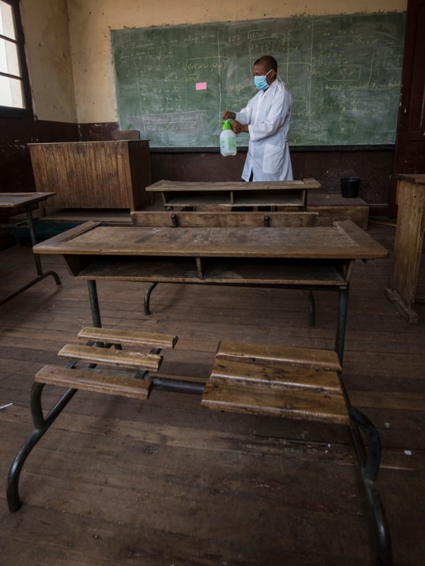 A member of staff at a school in Antananarivo sprays against plague in a classroom. Photo / AP