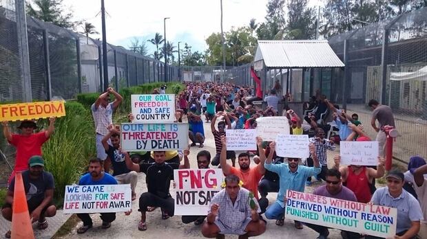 Refugees and asylum seekers hold up banners during a protest at the Manus Island immigration detention centre in Papua New Guinea. Photo / AP