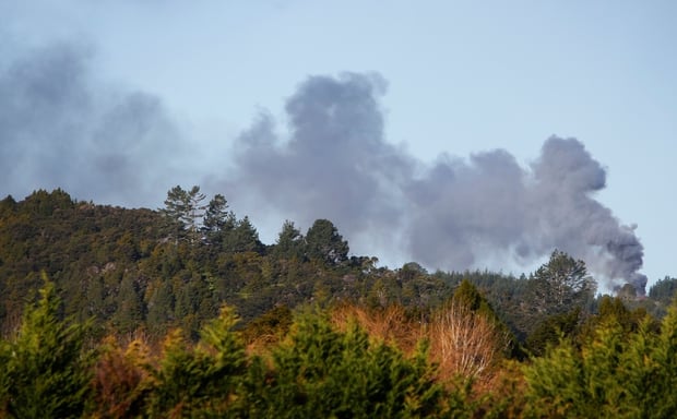 Smoke rises from the Mt Tiger Rd house after it was set on fire. Photo / Michael Cunningham