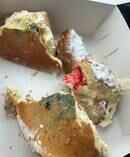 Photos posted by an Auckland man of a doughnut purchased from the bakery shows blue mould spotted over its base. Photo / Facebook
