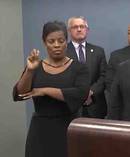 Police say they did not request an interpreter for the press conference, and are baffled as to why Roberts (circled) was there signing gibberish.