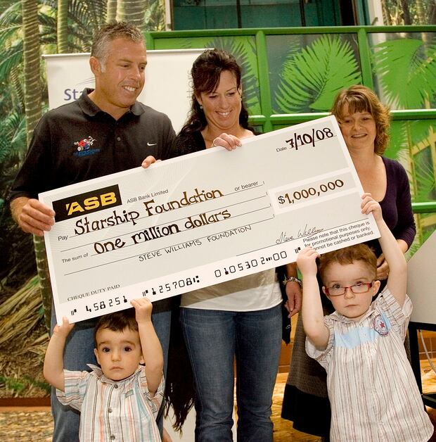 Steve Williams presenting a $1m cheque. Photo / NZPA