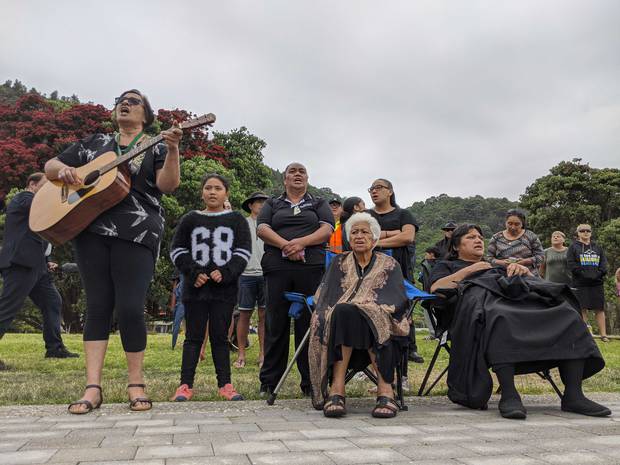 Local sing at the wharf in Whakatane as the bodies of six people are recovered from Whaakari / White Island. Photo / Amelia Wade 