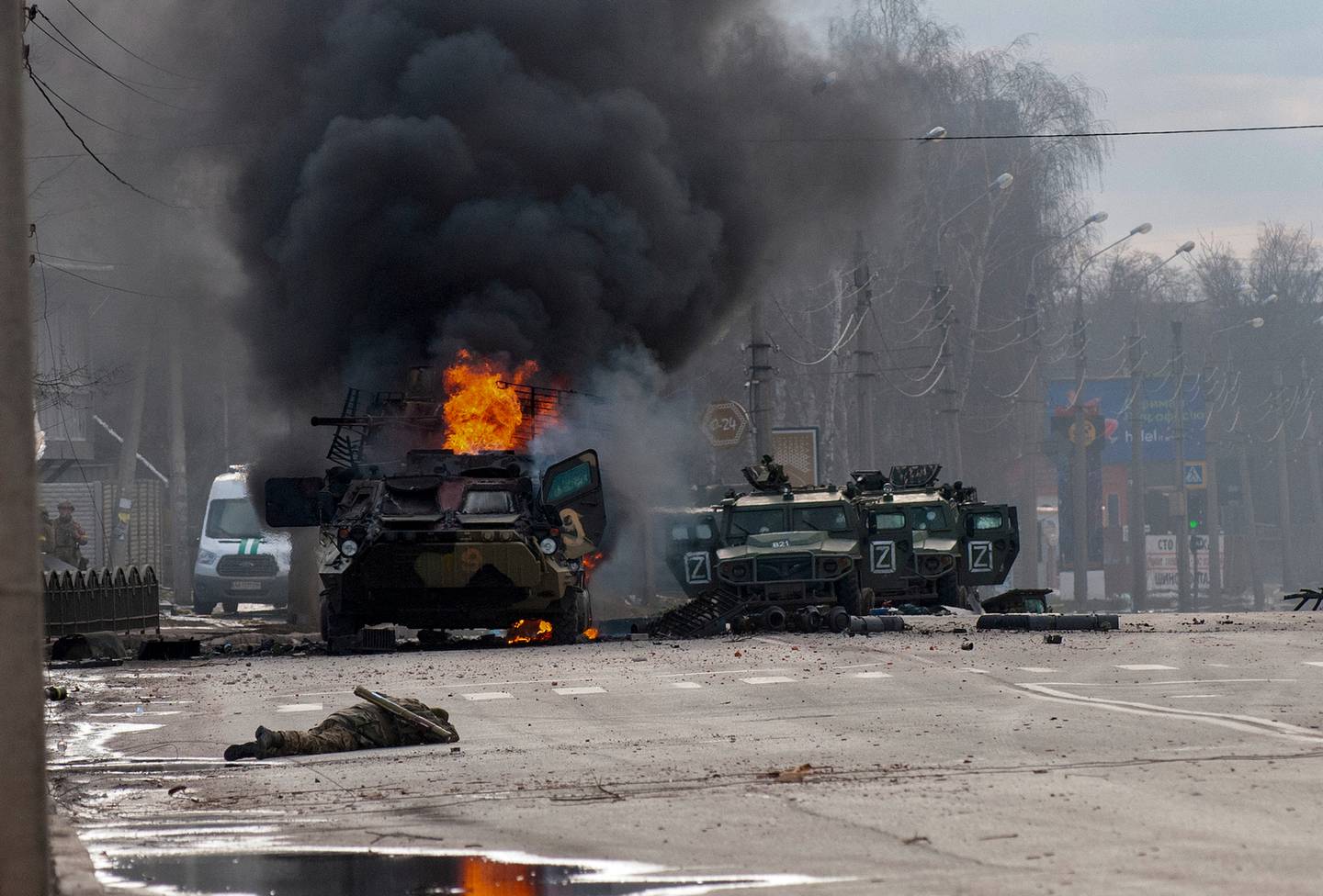 周日，在乌克兰哈尔科夫发生战斗后，一辆装甲运兵车被烧毁并损坏的轻型多用途车被遗弃。 照片/美联社