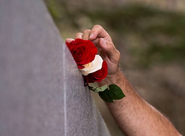 Stephen Thompson, from Atlanta, places roses on a monument as he remembers his father Ernest Thompson, who perished in the crash of Swissair Flight 111 twenty years ago. Photo / AP
