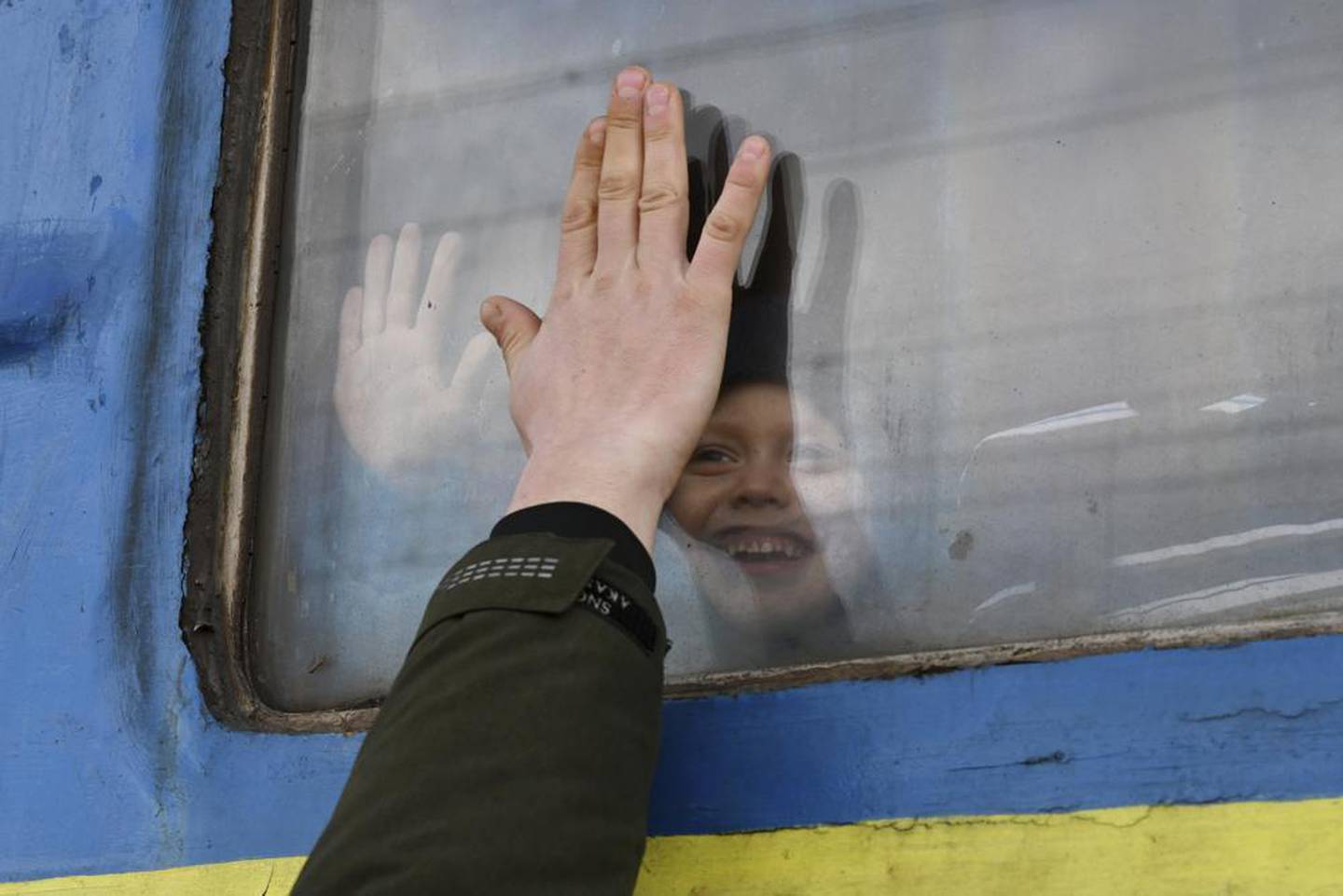 一个孩子在克拉马托尔斯克的火车站向一位从火车车厢窗外望去的亲戚道别。 照片/美联社