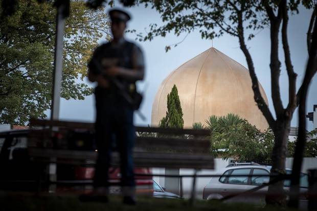 An armed police officer guards the Al Noor mosque. Photo / Michael Craig