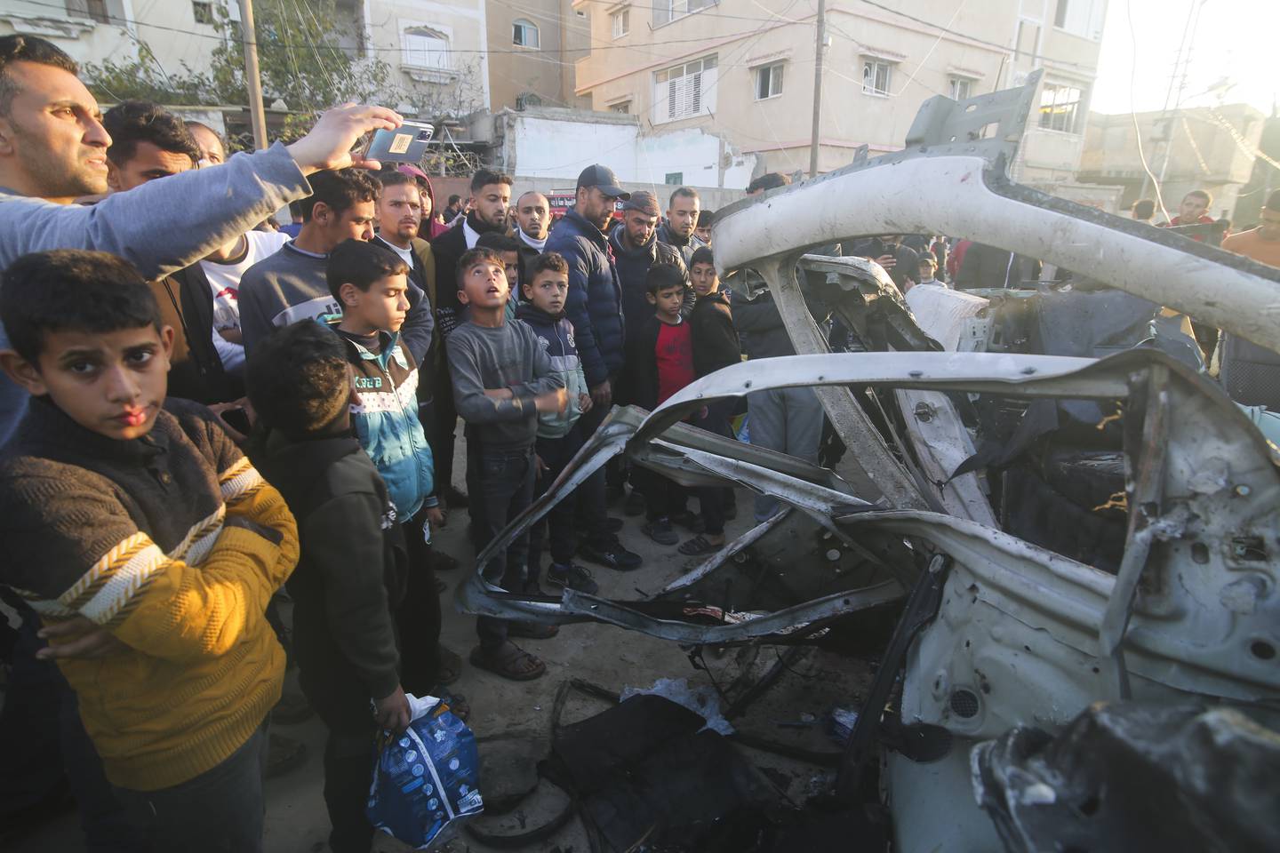 Filistinliler, Gazze Şeridi'nin Refah kentinde İsrail'in hava saldırısı sonucu vurulan Hamas polis aracının etrafında toplandı.  Fotoğraf / AP