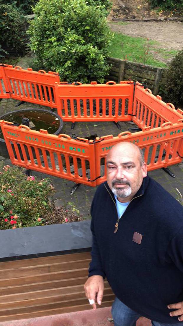 Andrew Thomson stand above the sinkhole that swallowed him up as he fed his fish.