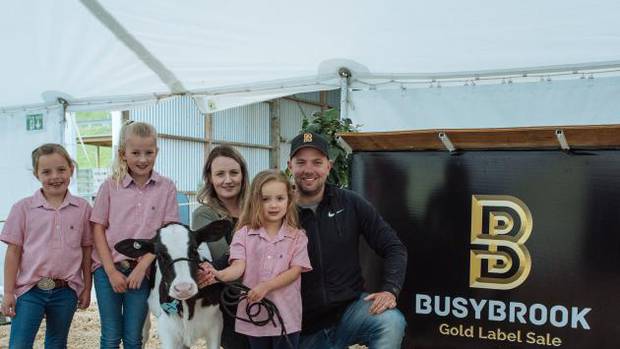 Nathan and Amanda Bayne with their daughters Brooke, Sophia and Lilly-Grace and 6-week-old heifer calf Hailstorm. Photo / PGG Wrightson