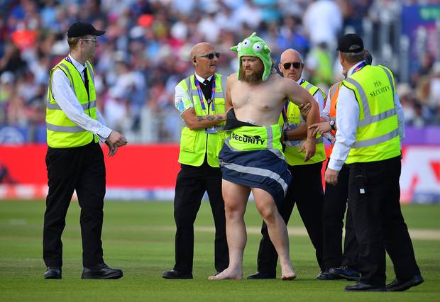 A streaker is taken from the ground in the World Cup game between England and New Zealand. Photo /Getty