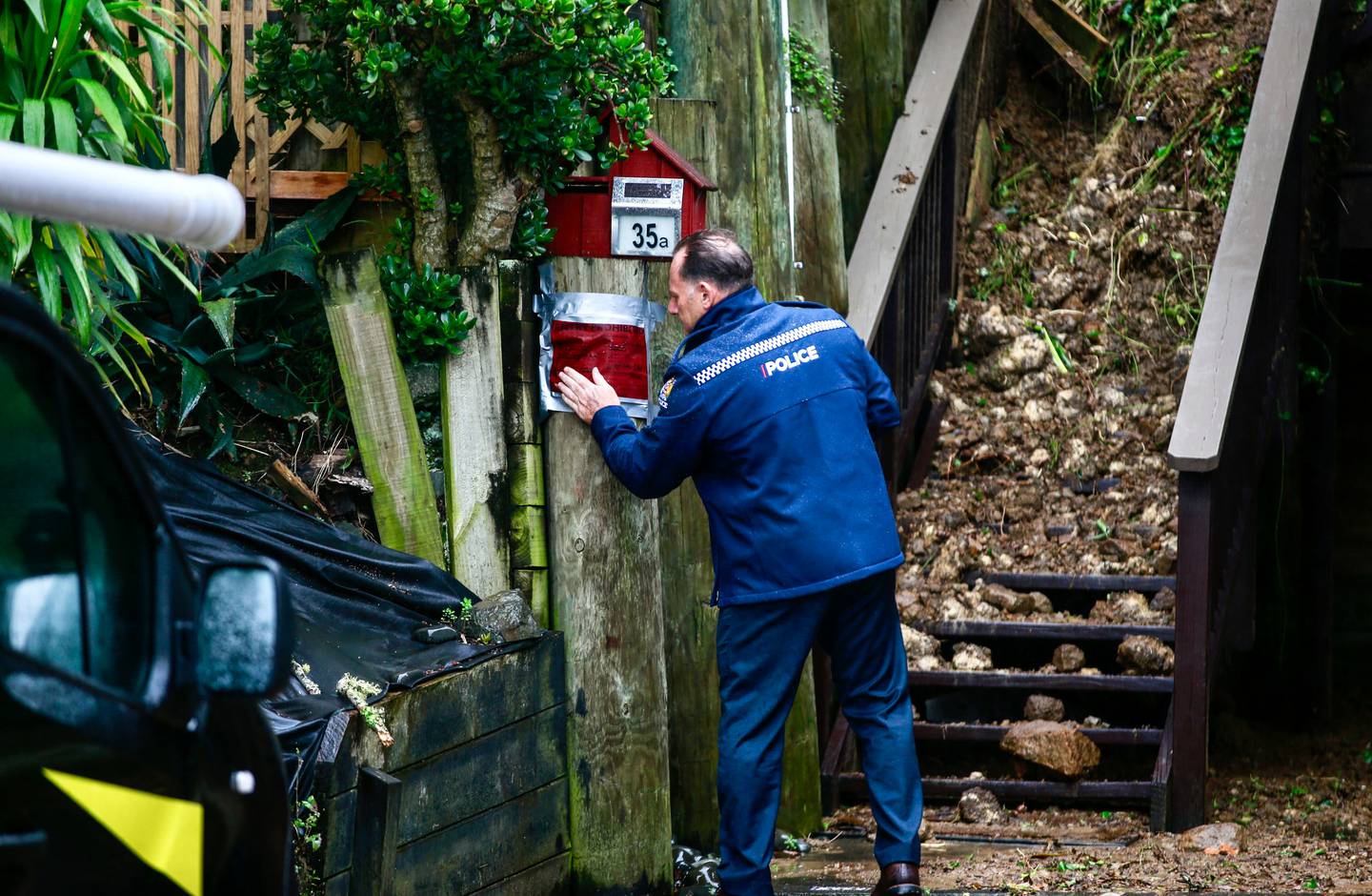 在暴雨导致奥克兰地区发生山体滑坡和大面积破坏后，一名警察在 Remuera 的 Shore Rd 的一所房子上贴了一张红色贴纸。 照片/亚历克斯·伯顿