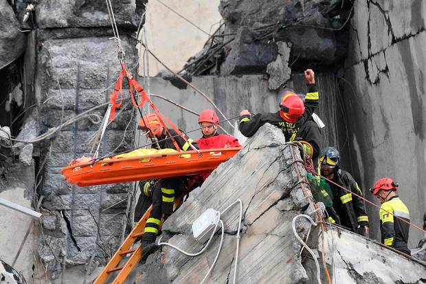 Rescuers work to recover an injured person after the Morandi highway bridge collapsed in Genoa, northern Italy. Photo / AP 