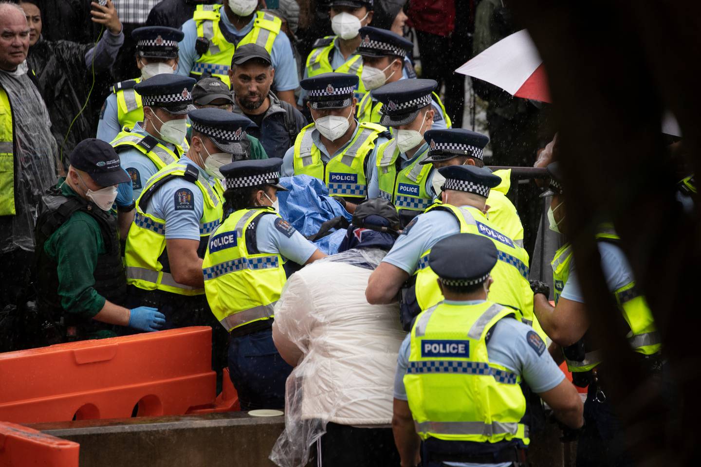 A person is carried out on a stretcher from the protest at Parliament. Photo / George Heard