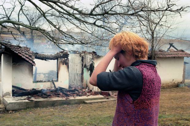 Me kokÃ«n e saj nÃ« duart e saj, njÃ« vajzÃ« e re etnike shqiptare qÃ«ndron para familjes sÃ« saj ndÃ«rsa ajo digjet nÃ« tokÃ« nÃ« fshatin ShtitaricÃ« tÃ« KosovÃ«s.  Foto / PÃ«rplas Goddard