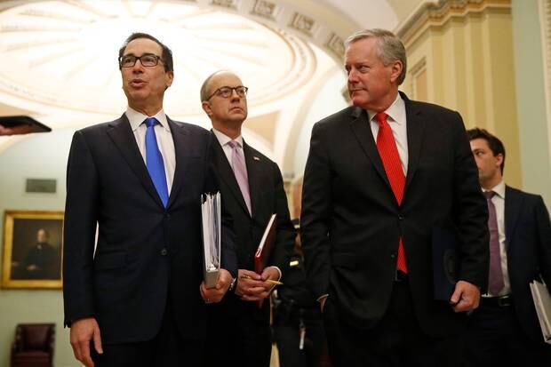 Treasury Secretary Steven Mnuchin, left, accompanied by White House Legislative Affairs Director Eric Ueland and acting White House chief of staff Mark Meadows, speaks with reporters. Photo / AP