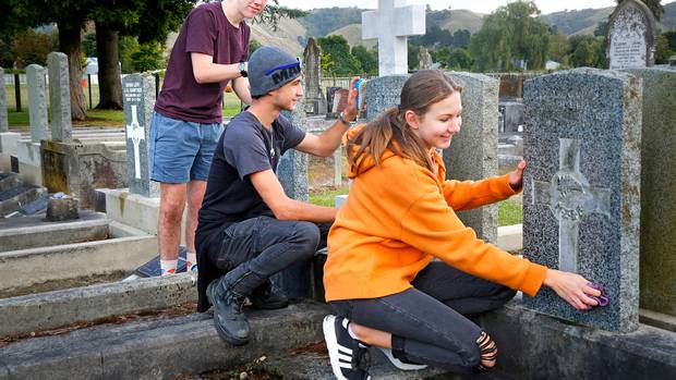 Air cadets Reuben Gould (left), Max McIntyre and Sophie Baldwin cleaning war graves at Aramoho Cemetery. Photo/Bevan Conley