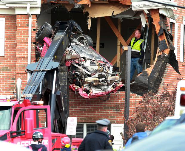 A Porsche is removed form the second story of a building after the convertible went airborne and crashed into the second floor. Photo / AP