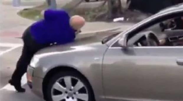 Witnesses desperately tried to get the man to move away from the woman's car and into safety. Photo / Twitter 
