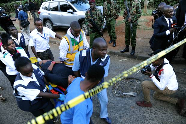 A pregnant woman is helped by medics and military police following a blast in Nairobi, Kenya. Photo / AP