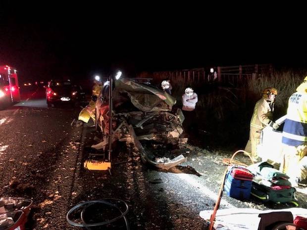 Emergency services at the scene of the crash on State Highway 16 north of Auckland last night. Photo / Auckland Rescue Helicopter Trust