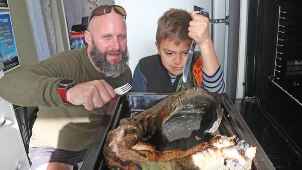 Chris Friedel and Maihi Brown tuck into some eel at the Whanganui High School Hangi. Photo / Bevan Conley