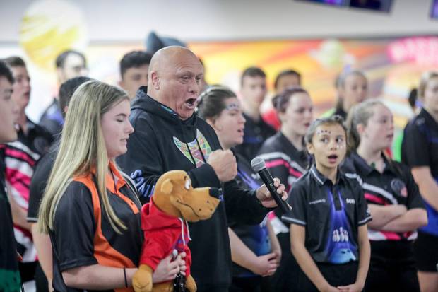 Henare O'Keefe, a member of the Hastings District Council, sings the national anthem with competitors at the NZ Junior Youth Tenpin Bowling national championships, Hastings. Photo / Warren Buckland