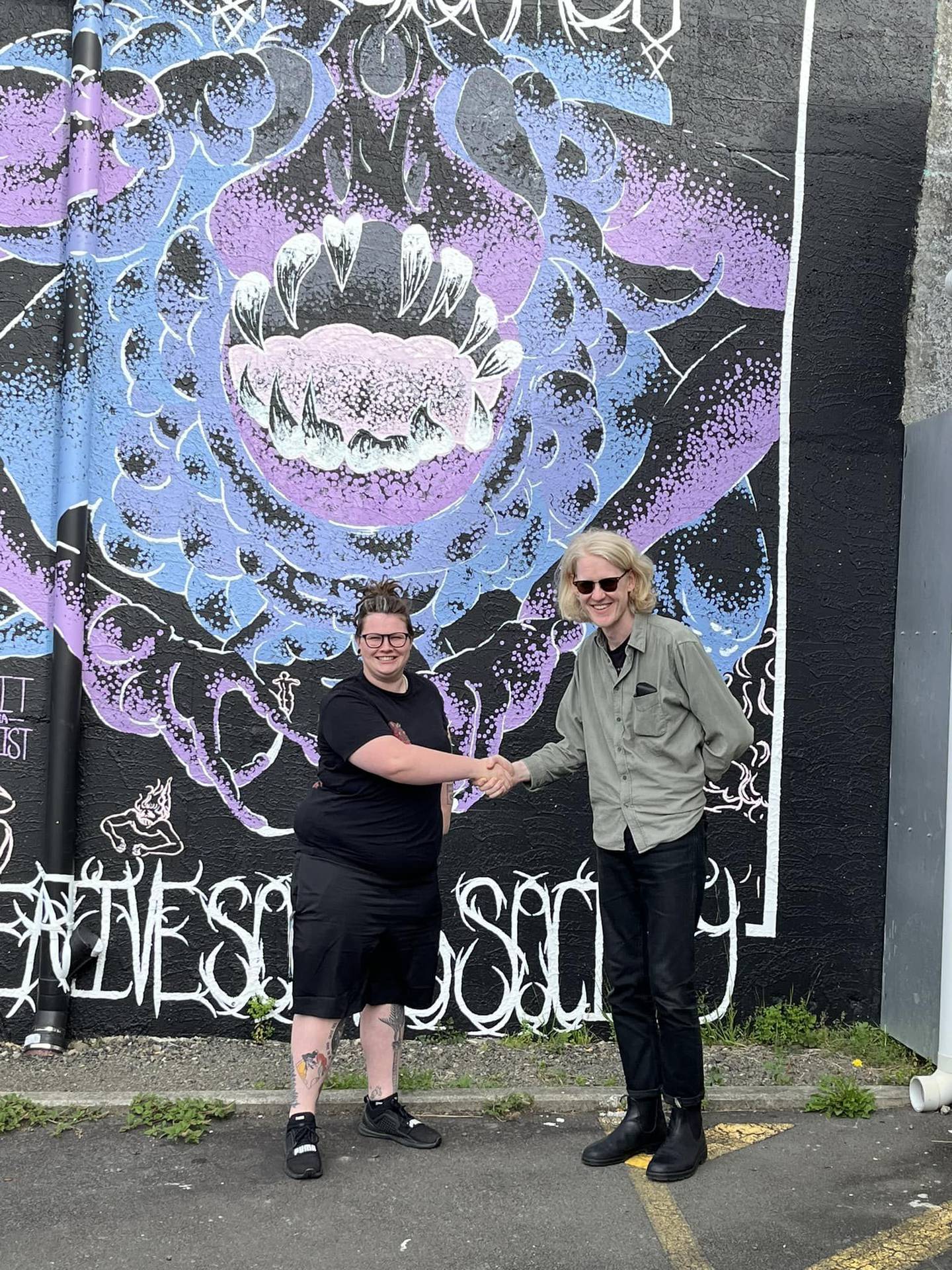 The Stomach community outreach coordinator Abi Symes shakes hands with manager Harry Lilley. Symes will take over from Lilley at the end of April. Photo / Supplied