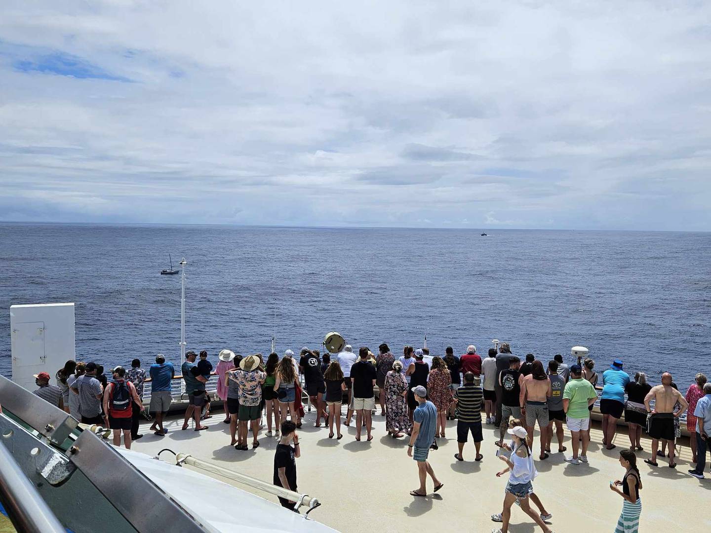Cruise guests aboard the Pacific Explorer as the ship assisted the NZ-flagged yacht in distress. Photo / Ali Gilchrist