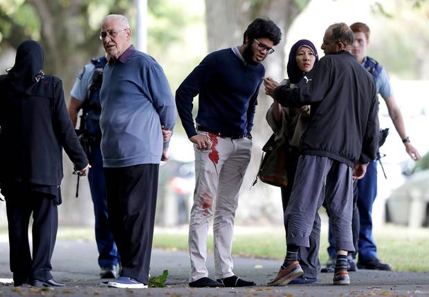 People stand across the road from a mosque in central Christchurch. Photo / AP