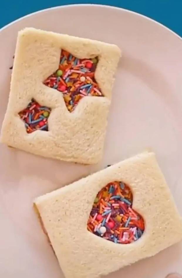 It doesn't end there - he doesn't cut it up in triangles. Instead, he uses a cookie cutter to form love heart and star shaped cut-outs in another change to the original - a sandwich lid. Photo / TikTok@Lunchboxdad