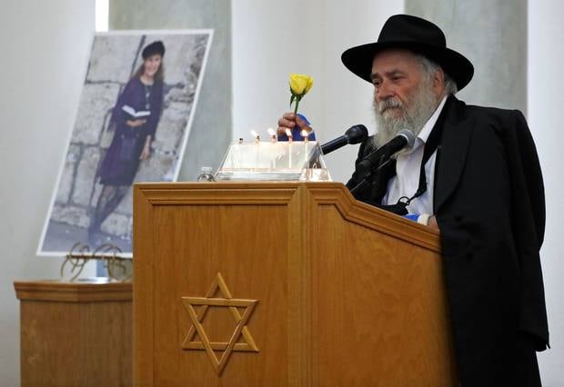 Yisroel Goldstein, Rabbi of Chabad of Poway, holds a yellow rose as he speaks at the funeral for Lori Kaye, who was killed when John Earnest opened first at a synagogue. Photo / AP