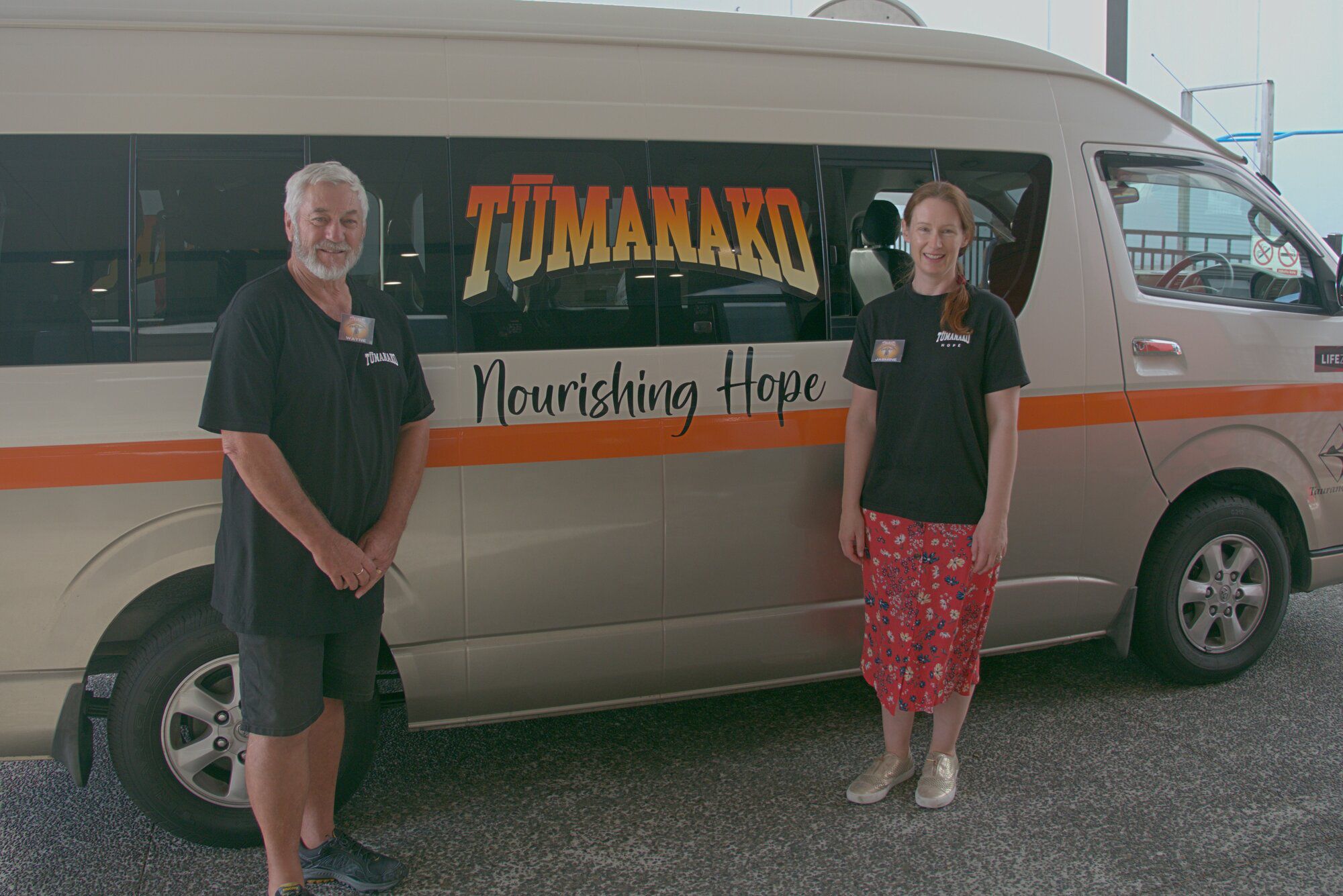 Wayne Shadbolt and Jasmine Pearson at the Tūmanako shuttle bus that picks up folks who cannot make their own way to Life Zone Church, Judea.
