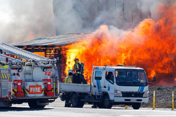 Firefighters at the scene where fire burns through a container terminal at the Port of Tauranga. Photo/Andrew Warner