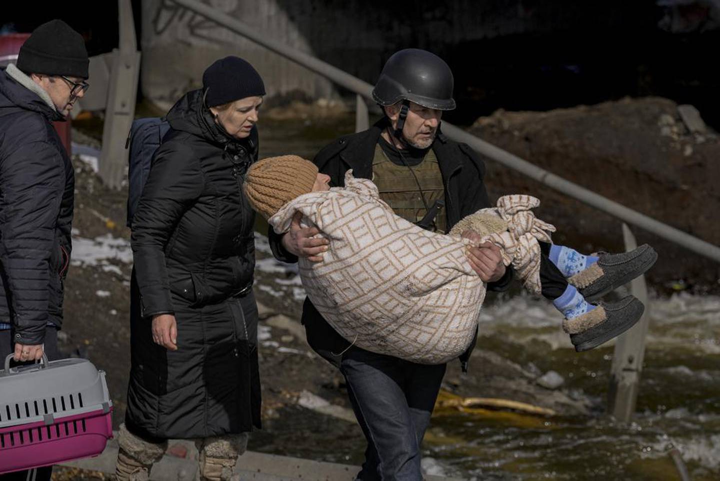 2022 年 3 月 8 日，星期二，在乌克兰基辅郊区，随着人们继续离开伊尔平，一名男子抱着一名老年妇女。照片/美联社