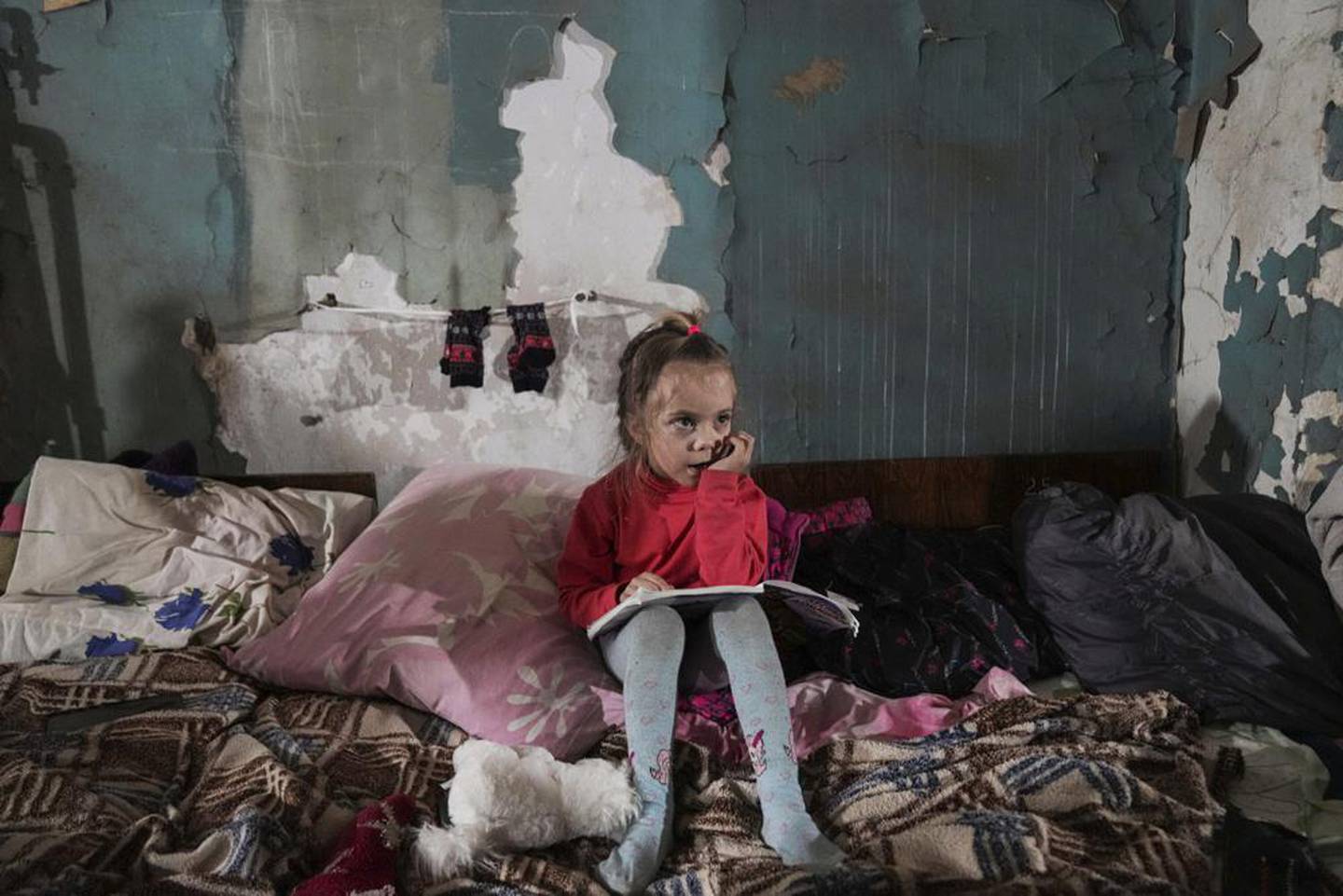 2022 年 3 月 7 日星期一，一个女孩坐在乌克兰马里乌波尔的临时防空洞里。照片/美联社
