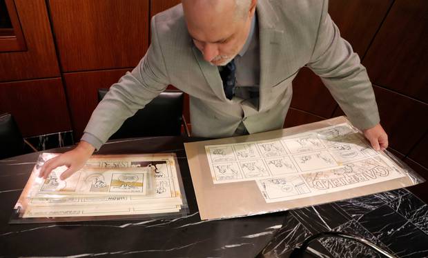 Heritage Auctions collectables specialist Brian Wiedman displays Garfield comic artwork drawn by creator Jim Davis in Dallas. Photo / AP