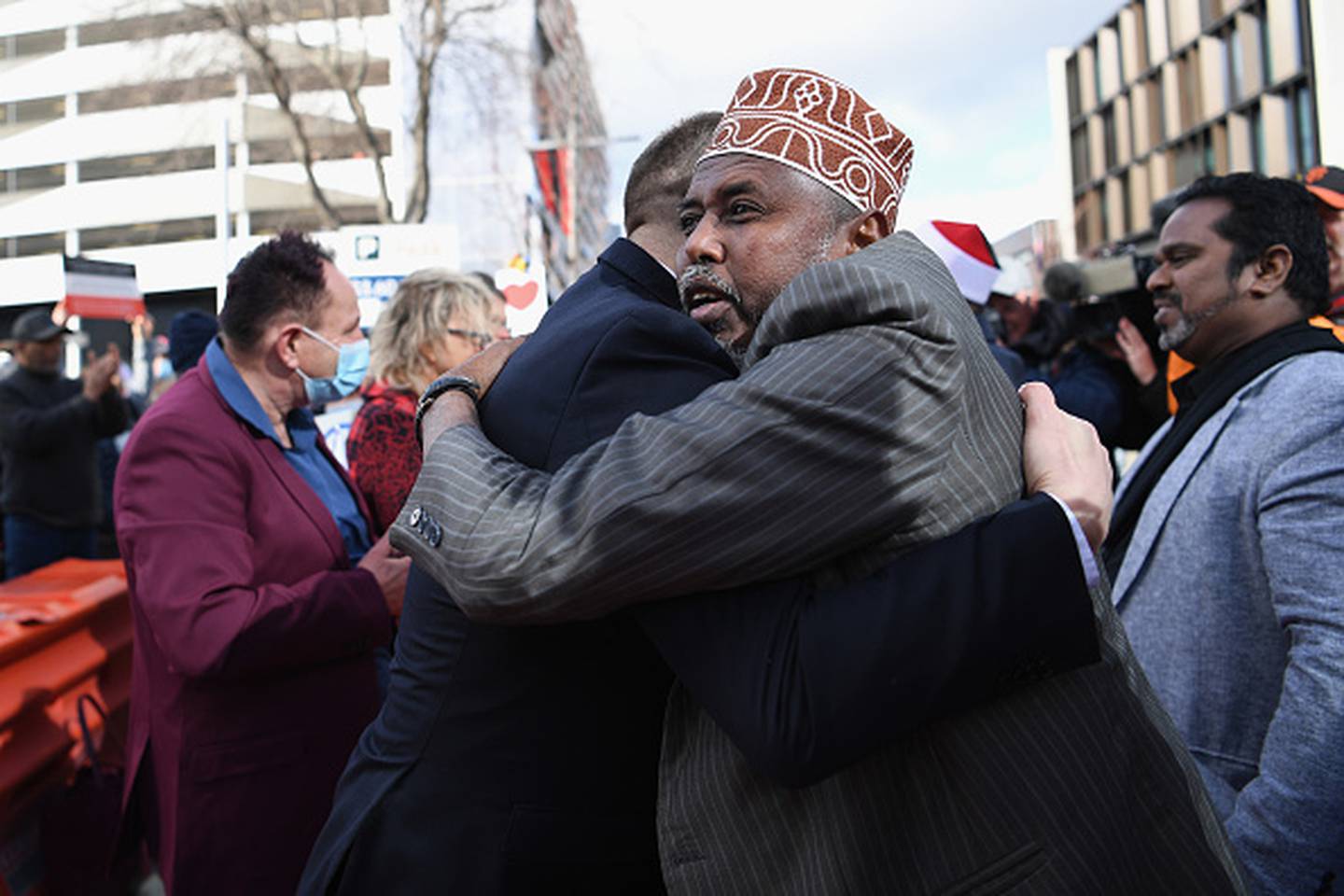 Muslim Association Canterbury President Mohamed Jama celebrates with members of the public outside Christchurch High Court following the sentencing of Brenton Tarrant.