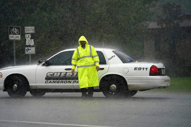 A Cameron Parish Sheriff's deputy mans a roadblock in the rain on LA 27 as residents evacuate Cameron in Lake Charles, Louisiana. Photo / AP