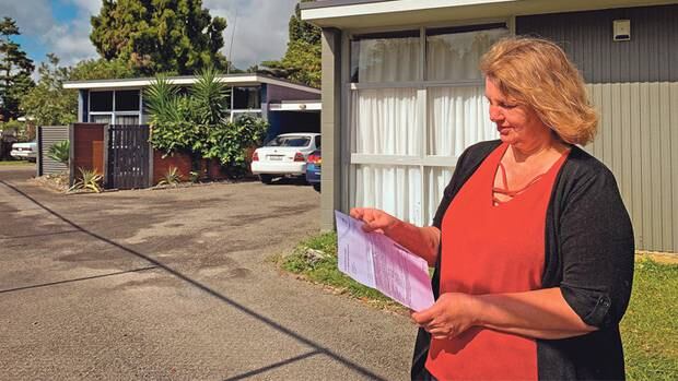 Diane McCarthy reads her owner's notice which saw her flat valued significantly higher than her identical neighbours'. Photo / Charlotte Jones / LDR