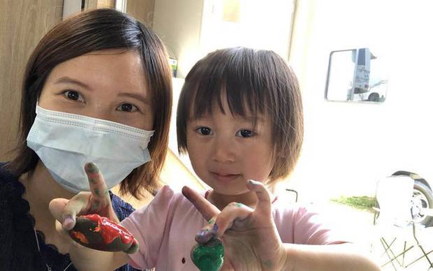 Lily Gao painting rocks with her 2-year-old daughter Elysse in the campervan. Photo / Lily Gao