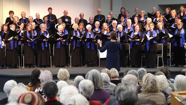 Lynn Whiteside conducts the Wanganui Community Choir in songs across nine decades. Photo / Bevan Conley