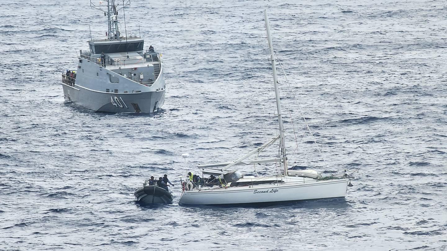Fijian Navy sailors board the distressed yacht from the RFNS Savenaca. Photo / John McFarlane